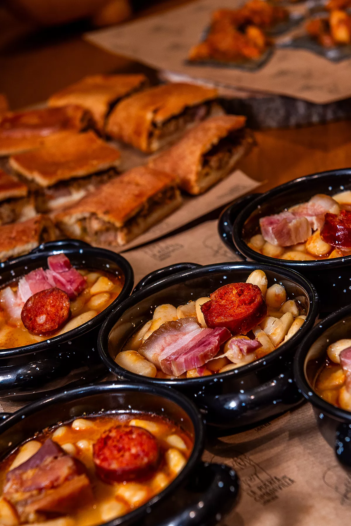 Bodegón con cazuelitas de fabada y empanada